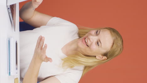 Vertical-video-of-The-woman-who-likes-the-application-on-the-laptop-is-happy.